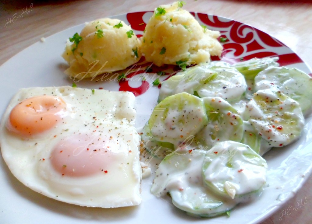 Fried egg with potatoes and cucumber salad